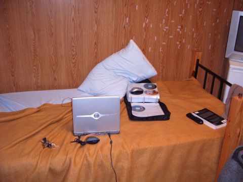 1988 Ford Bronco - A bed is set up with a laptop and CDs, suggesting a personal space.