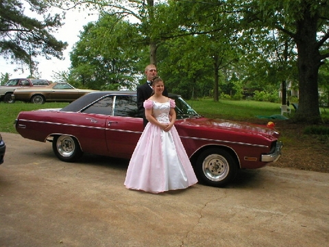 1979 Ford F-150 - A young couple poses for a photo next to a vintage car, with other vehicles in the background.