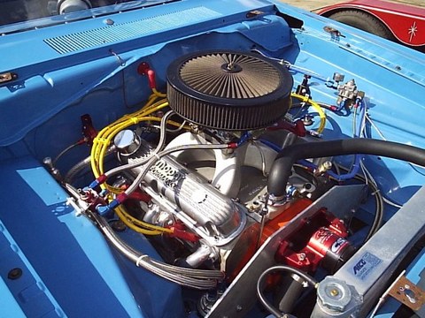 1979 Ford F-150 - Close-up view of a modified V8 engine in a blue vehicle, showing custom fuel lines and wiring.