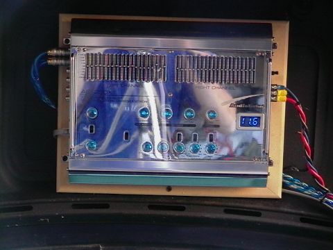 1995 Ford Contour - An Audiobahn amplifier is installed in a vehicle's interior, numerous blue knobs and a digital voltage display.