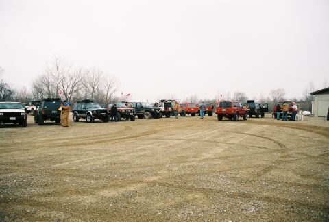 1995 Ford Bronco - A gathering of SUVs in a gravel lot, possibly for an off-road event or meetup.