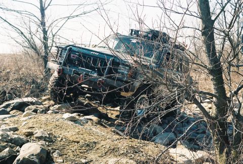 1995 Ford Bronco - A modified Jeep Cherokee XJ tackles a challenging rocky trail during an off-road excursion.