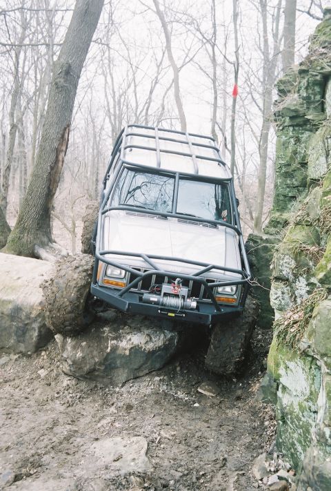 1995 Ford Bronco - Modified Jeep Cherokee XJ tackling a challenging off-road obstacle course.