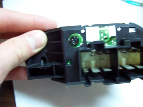 1999 Ford Taurus - back of the switch, looking thru the hole where you unscrew the bulb from. flat head screw driver works best, of course.