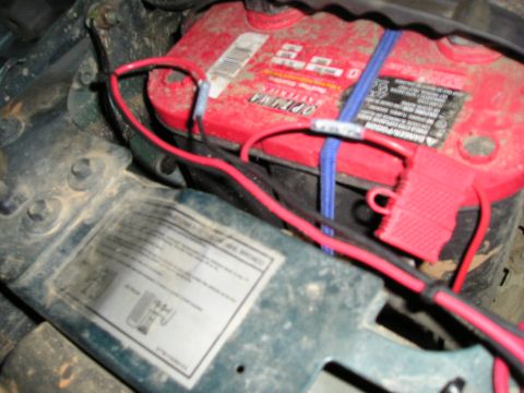 1996 Ford Bronco - Close-up of a vehicle's battery and wiring, showing a red Optima battery with connected cables.