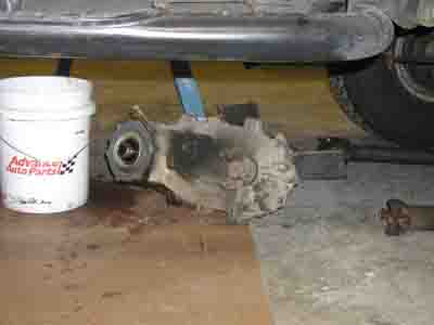 1988 Ford Bronco - Differential housing and a white bucket are visible under a vehicle, possibly during maintenance.