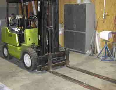 1988 Ford Bronco - A forklift is parked indoors, ready for use. The image includes a large cabinet and various tools in the background.