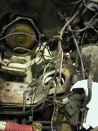 1988 Ford Bronco - A close-up view of a complex automotive wiring harness and engine parts.