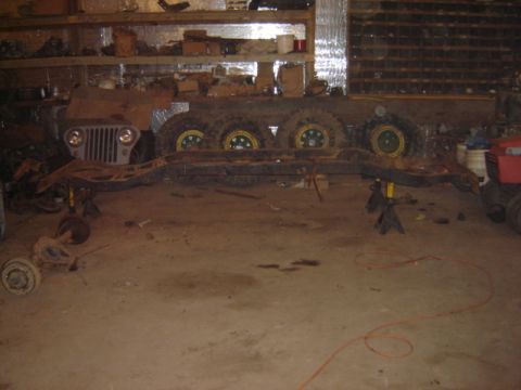 1992 Ford Bronco - Jeep CJ-6 chassis and front body section undergoing restoration or repair in a workshop.