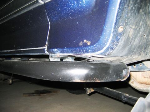 1985 Ford Bronco - Underside view of a blue vehicle, revealing the rocker panel and suspension details.