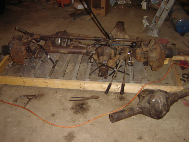 Two rusty differential assemblies on a wooden pallet and the floor