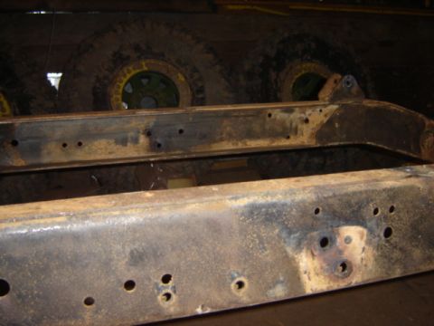 1992 Ford Bronco - Close-up of a heavily rusted vehicle frame, showing mounting holes and structural components.
