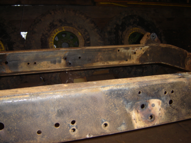 rusted vehicle frame with holes drilled in it