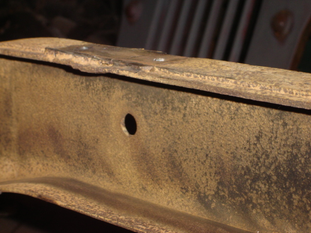 close-up of rusty metal frame with a hole in it, has supermotors.net watermark