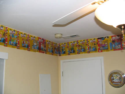 1994 Ford Crown Victoria - The Simpsons toys are displayed in their packaging along the top of a wall.