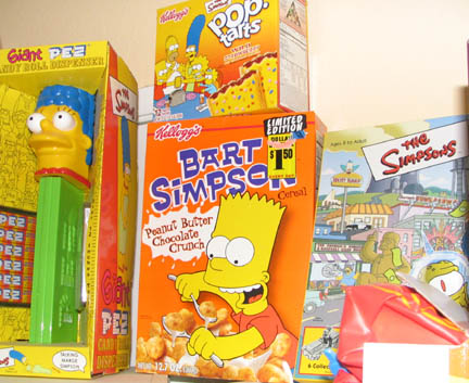 1994 Ford Crown Victoria - A collection of The Simpsons themed merchandise, including Bart Simpson cereal and a PEZ dispenser, is displayed on a shelf.