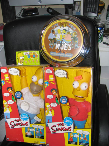 1994 Ford Crown Victoria - The Simpsons collectibles are displayed on a chair, including action figures, a clock, and cookies.