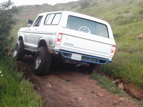1978 Ford Bronco - This Ford Bronco is navigating a steep, off-road trail with a spare tire mounted inside.