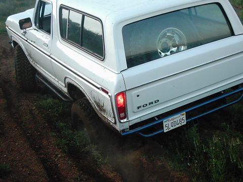 1978 Ford Bronco - 1978 Ford Bronco navigating muddy terrain with a blue aftermarket rear bumper.