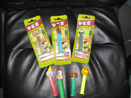1994 Ford Crown Victoria - Collection of PEZ dispensers, including Mr. Bean characters, displayed on a dark, textured surface.