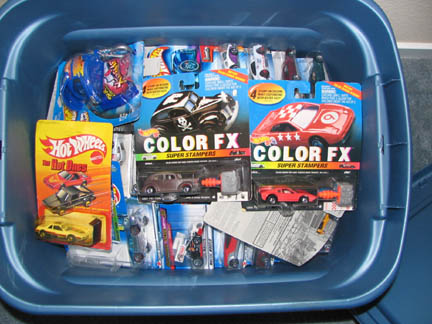 1994 Ford Crown Victoria - A blue bin filled with various Hot Wheels toy cars and accessories.