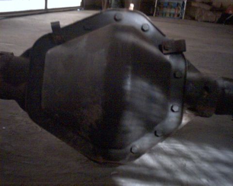 1990 Ford Bronco - A dark differential housing with visible bolts and axle tubes is shown.