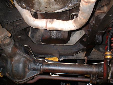 1978 Ford Bronco - A close-up view of the undercarriage reveals the vehicle's drivetrain components and exhaust pipes.
