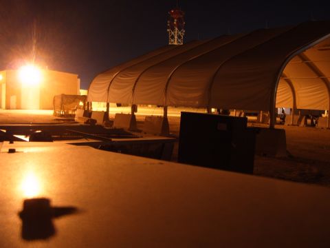1988 Ford Bronco - Nighttime view of a military installation large tents and buildings under a dark sky.