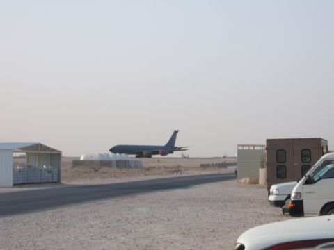 1988 Ford Bronco - A military jet is on the tarmac, with several vehicles parked in the foreground.