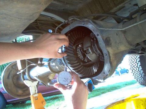 1988 Ford Bronco - Mechanic uses a dial indicator to measure backlash in a vehicle's differential assembly.