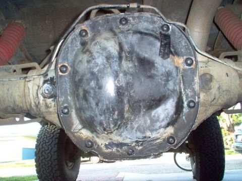 1988 Ford Bronco - Close-up view of a vehicle's rear differential cover, with visible suspension components and a tire.