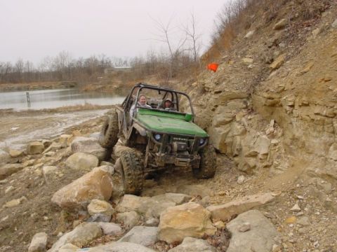 1992 Ford Bronco - This off-road vehicle, identified by a "SUZUKI" badge, navigates a challenging rocky path.
