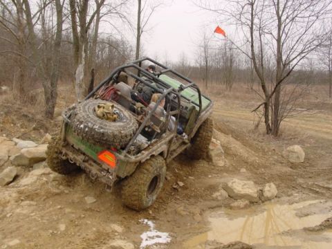 1992 Ford Bronco - Off-road vehicle navigating a challenging rocky and muddy course.