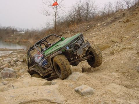 1992 Ford Bronco - This green off-road vehicle navigates a challenging rocky path, demonstrating its off-road capabilities.