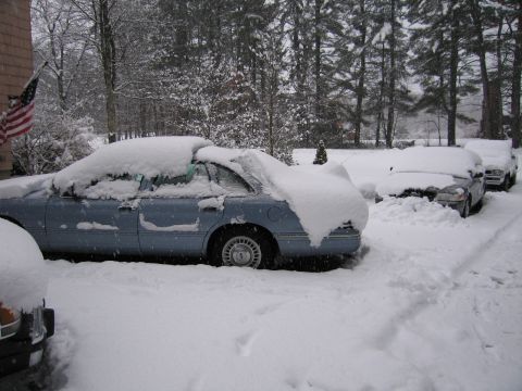 2001 Ford Crown Victoria - A light blue 2001 Ford Crown Victoria sits parked on a snowy day, partially obscured by snowdrifts.