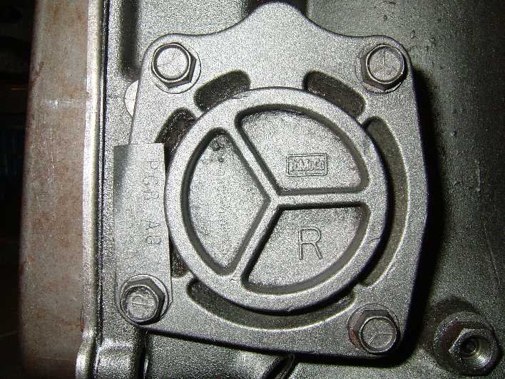 Cast FoMoCo cover with three-spoke design, stamped R, and PCB A8 tag on Ford drivetrain component