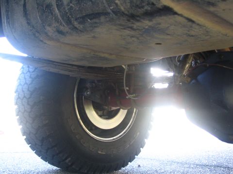 1987 Ford Bronco - This photo shows the rear axle and suspension components of a vehicle, including leaf springs and a tire.