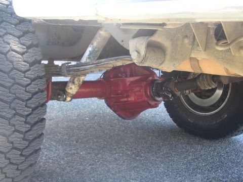 1987 Ford Bronco - Close-up view of the undercarriage, focusing on the rear axle and suspension of a vehicle.