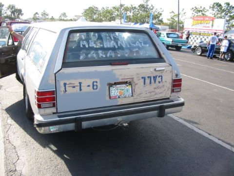 1997 Ford Crown Victoria - A station wagon is parked in a lot, with writing on its rear window and a license plate.