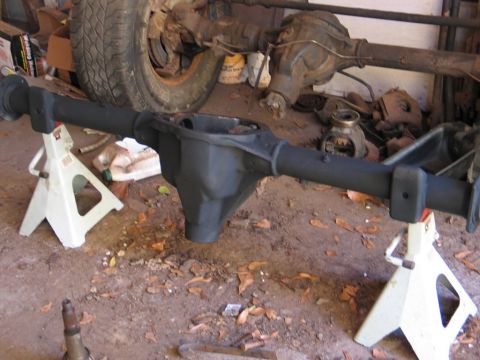 1989 Ford F-150 - A disassembled rear axle assembly is supported by jack stands, with the differential housing and axle tubes clearly visible.