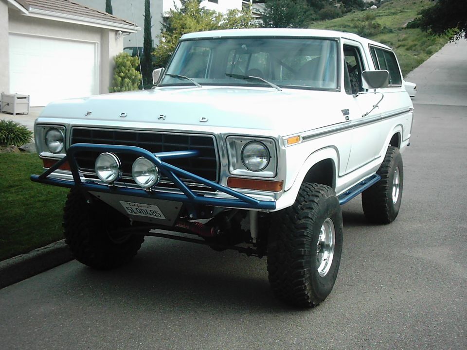 1978 Ford Bronco with blue off-road bumper and lights, lifted suspension, and large tires