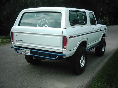 1978 Ford Bronco - A white 1978 Ford Bronco is parked on a paved surface, showing its rear end and side profile.