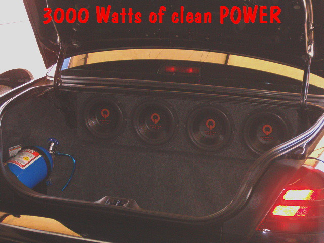 Car trunk audio build with four subwoofers and a blue nitrous bottle, '3000 Watts'