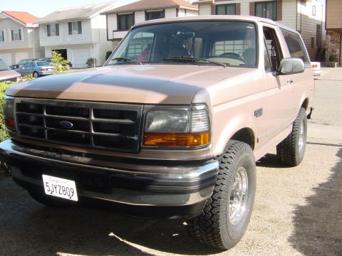 1996 Ford Bronco - This 1996 Ford Bronco is shown in a front three-quarter view, parked outside a residential garage.