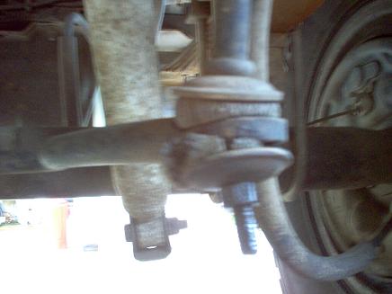 1988 Ford Bronco - This image shows a close-up view of a vehicle's suspension system, focusing on a ball joint and associated linkage.