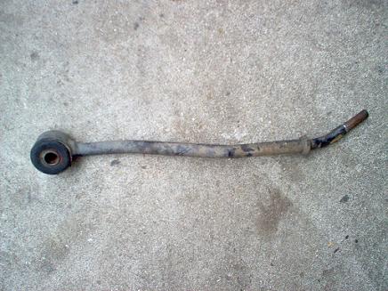 1988 Ford Bronco - This appears to be a worn suspension component, possibly a sway bar link, resting on a concrete surface.