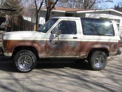 1986 Ford Bronco II - This weathered Ford Bronco II shows significant rust along its lower body panels.