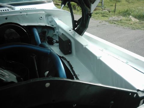1978 Ford Bronco - Close-up view of the engine bay, showing white painted metal and blue hoses.