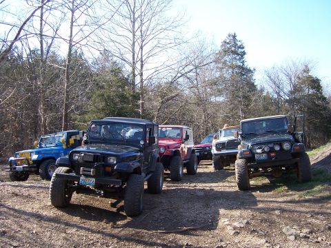 1999 Jeep TJ - Group of Jeeps gathered on a dirt path during an off-road outing.