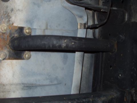 1993 Ford Bronco - Undercarriage view showing a hose and mounting hardware on a vehicle frame.